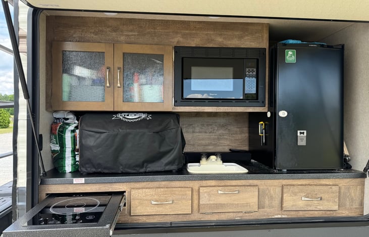 Outdoor Kitchen with refrigerator, microwave, sink and electric burner.
Optional Add Ons:
Pitboss table top pellet smoker.
Blackstone flat top griddle.