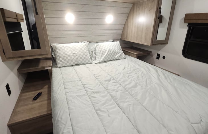 Queen size bedroom with a TV and separate thermostat for the ac unit.