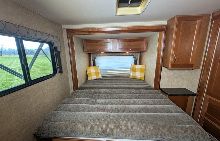 Cozy queen bed in the back with a slide-out closet and plenty of storage.