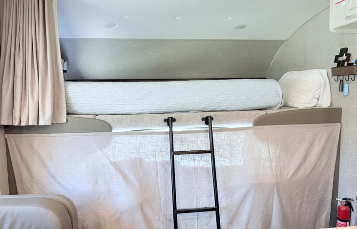 That is the driving area below. you can open this up or cover it like this if you want privacy. Bunk is a double bed and there is a window to the left