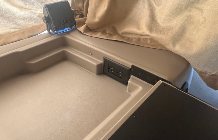 Front passenger seat with 110 outlet and automobile auxiliary power outlet (also known as car cigarette lighter or auxiliary power outlet).