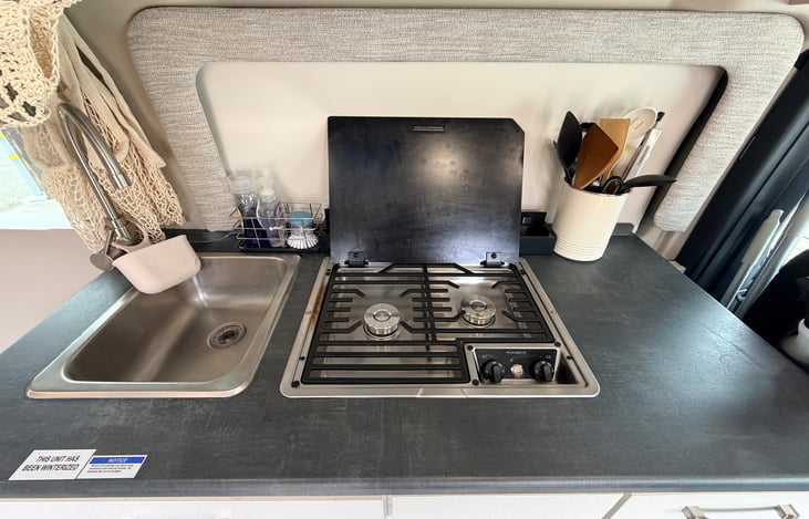 2-burner gas stove cooktop and kitchen sink. Basic cookware, silverware, and salt/pepper included.