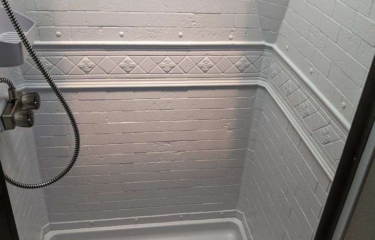 Walk in shower that is both wide and tall.