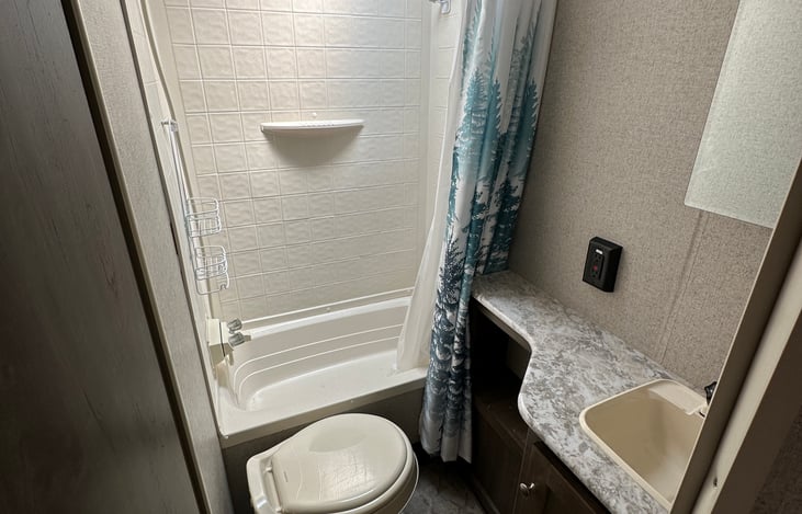 Bathroom stocked with toilet paper,shampoo, conditioner and body wash.