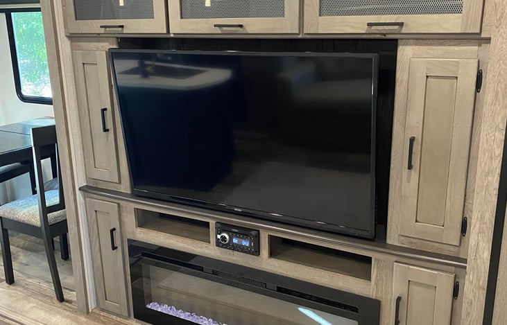 large screen TV above a beautiful electric fireplace that with artificial fire that burns in three colors and lots of heat..