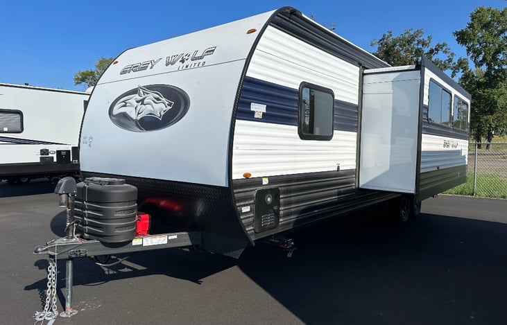 Spacious exterior layout with slide-out and two protected propane tanks