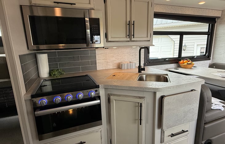 Kitchen sink and counter next to table making it handy.
