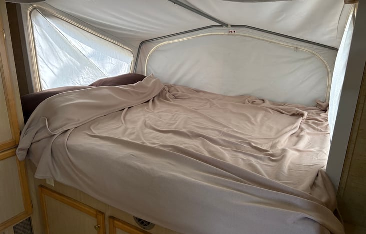 Front large queen bed complete with sheets pillows and blankets