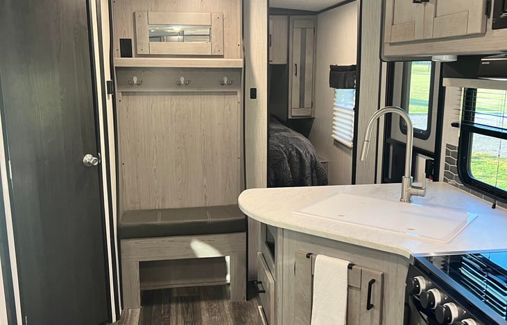 In this photo: looking towards the front door, you will see entry to the master room, kitchen and a full pantry