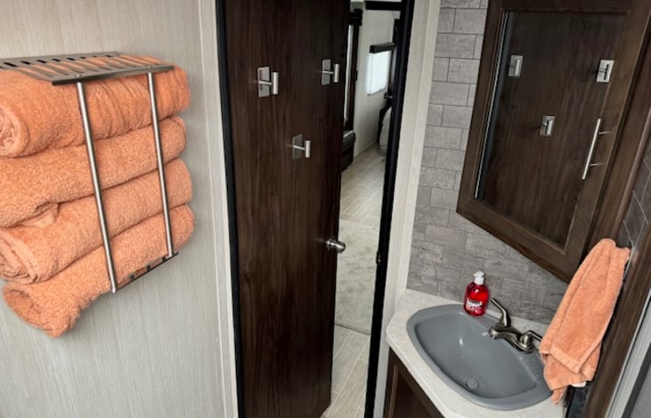 The bathroom comes stocked with 4 bath towels, a hand towel, toilet paper, and hand soap.