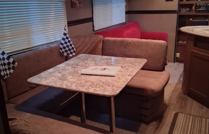 Bedroom with sliding doors for privacy. Memory foam queen sized bed, a tv/DVD player in room. Storage cabinets included in bedroom.  2 storage units under the seats