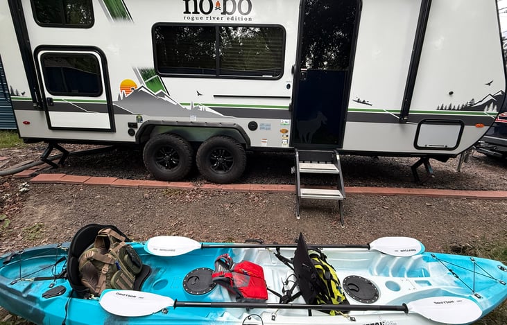 Fully loaded tandem kayak with three life vests and paddles.