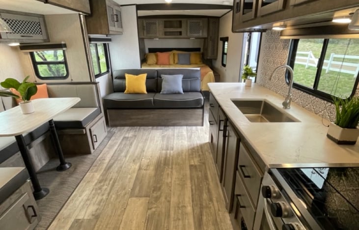 Slide out dinette, convertible sofa, kitchen area featuring lots of storage, and King size sleeping area in the back!