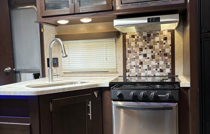Kitchen with oven, 3 burner stovetop, and microwave