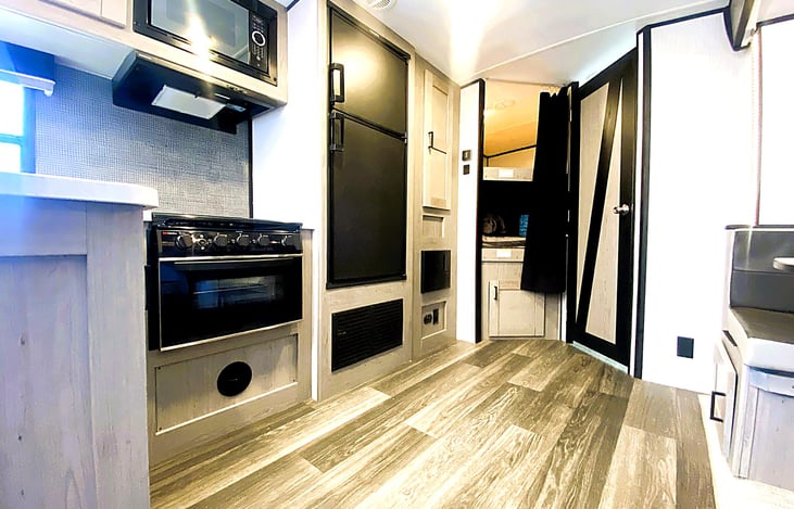 Central hallway view featuring kitchen, dinette, and bunk area — a favorite for group trips to Glendora, Carpinteria State Beach, or Bonita Ranch Campground.