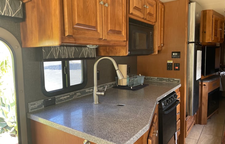 There is an oven, three burner stove and a microwave.