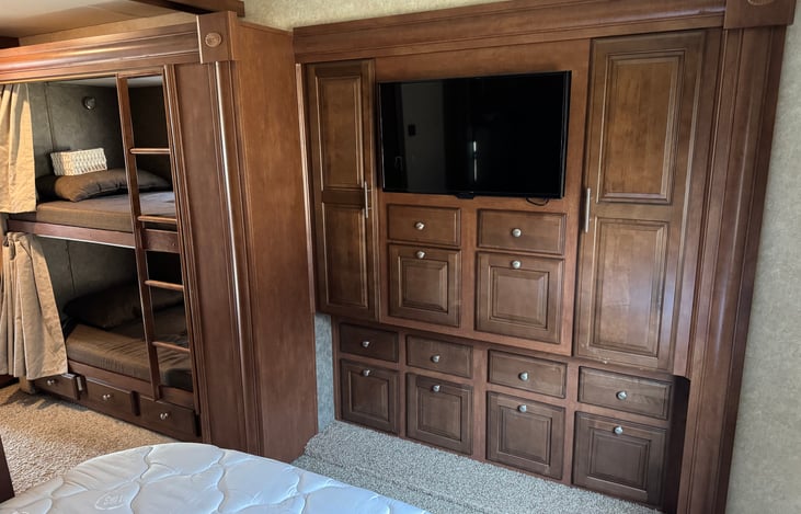 Master television and closets with drawer storage.