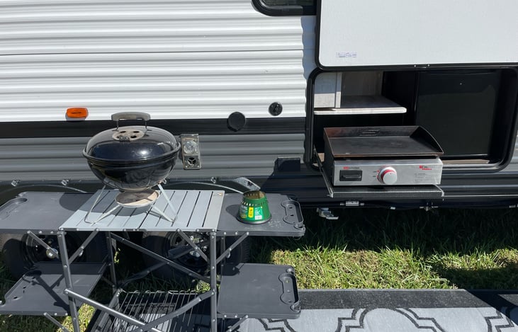 Outdoor kitchen. Griddle, fridge and charcoal grill