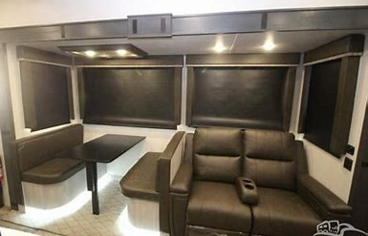 Two recliners that face the fireplace and dining area with expandable table.