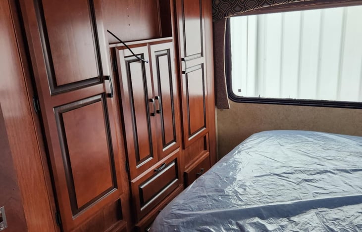 There is a small TV installed in opening above the middle doors. There is also an extra foam mat on the queen bed for extra support and comfort. The bed is a standard queen bed not a camper queen.