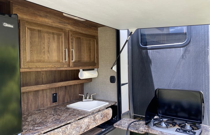 One of our favorite parts of this trailer is this outdoor kitchen. It provides the perfect shelter from wind and rain. Great stove, prep space, mini fridge and even a sink!