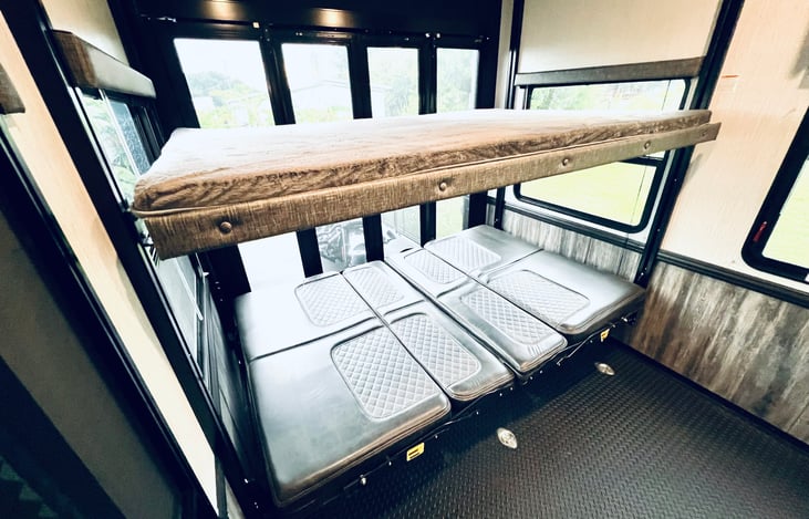 Bunk queen sized beds in a garage/ play area, with an access to the second patio.