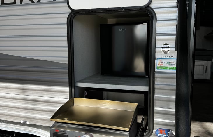 Outdoor grill and mini fridge.