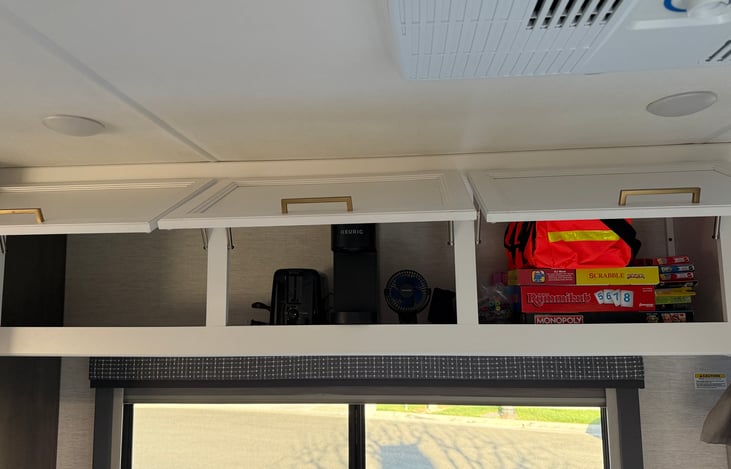Storage with board games, first aid kit, Keurig, toaster and portable fans
