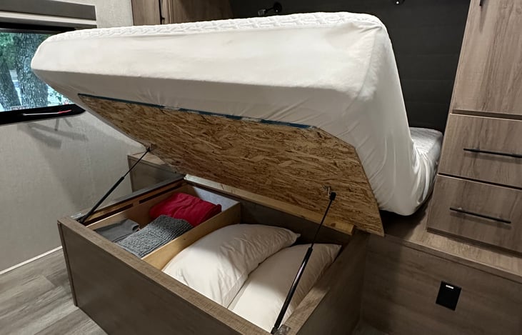 Under master bedroom bed is extra bedding and pillows