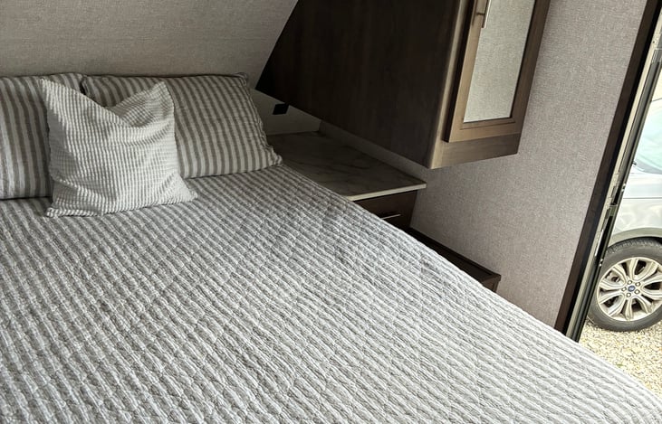 Spacious closet with hanging space for clothes and storage for belongings.