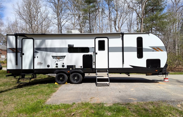 2023 Wildwood Platinum: Luxury family-ready rig with a King Master, double bunks, and Versa-Lounge. Enjoy the fireplace, bright modern interior, panoramic windows, outdoor kitchen large awning and mor