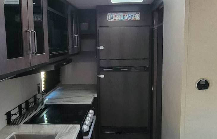 The kitchen features a long countertop space to prepare food or house camping snacks