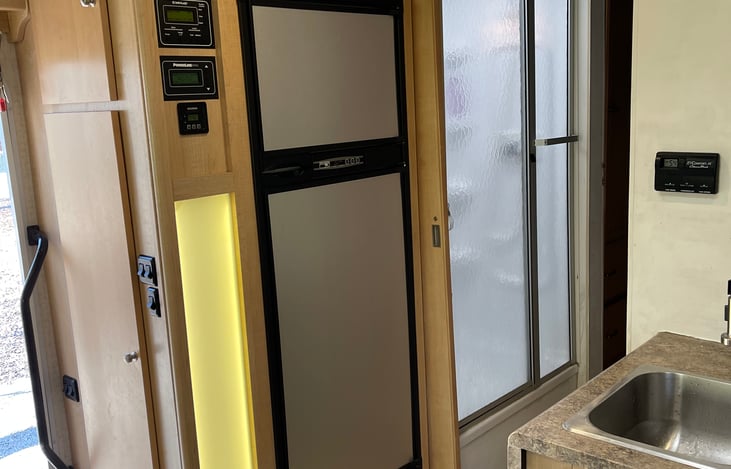 Refrigerator, Hallway shower, pantry, kitchen sink. External door is open on the left there.