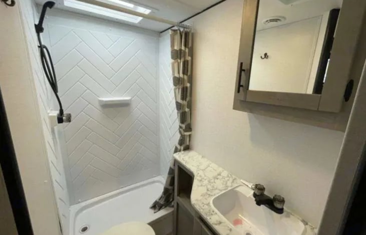 Tall shower ideal for taller individuals with medicine cabinet and under sink storage for bathroom essentials