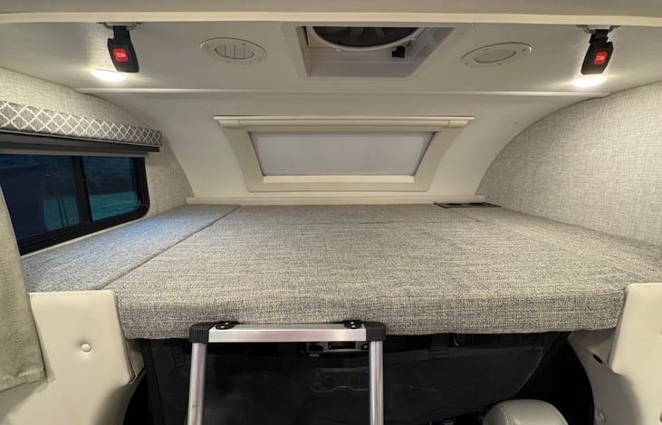 The above cabin bunk equals a full size bed, and easily sleeps persons over 6 ft tall. Motorized shade over front window and manual shade to the left with an operable window. Ladder attaches securely.