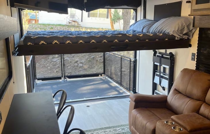 Bed comes down with manual hydraulic controls to sleep and goes back up during the day to have more space for activities. 

Back door also folds out into a porch for fresh air and patio platform!