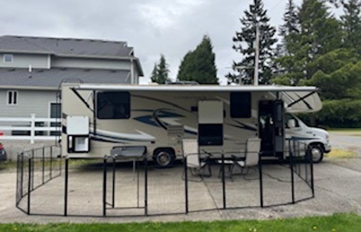 Setup with fencing and two lawn chairs and outdoor entertainment tv and stereo.