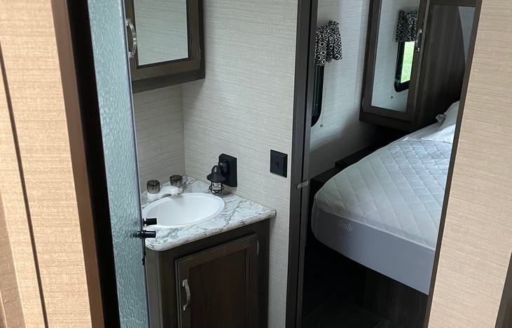 Walk-through bathroom connects living space to queen bedroom.