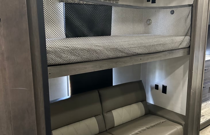 Bunks area with top bunk lowered. Lower bunk/couch slides out to make a double.