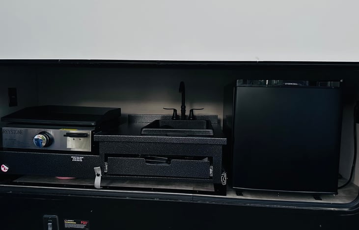 Outdoor kitchen includes griddle, sink and mini fridge