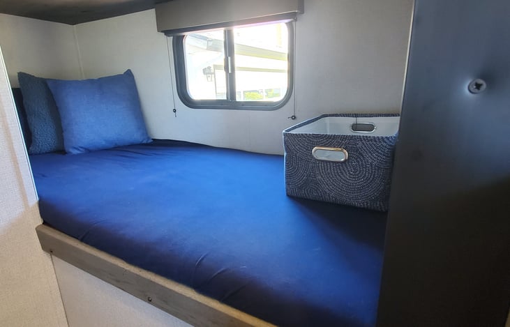 Bunk Beds with sheets, storage baskets, standard pillows and decorative pillows featured in the Glamping Package Addon