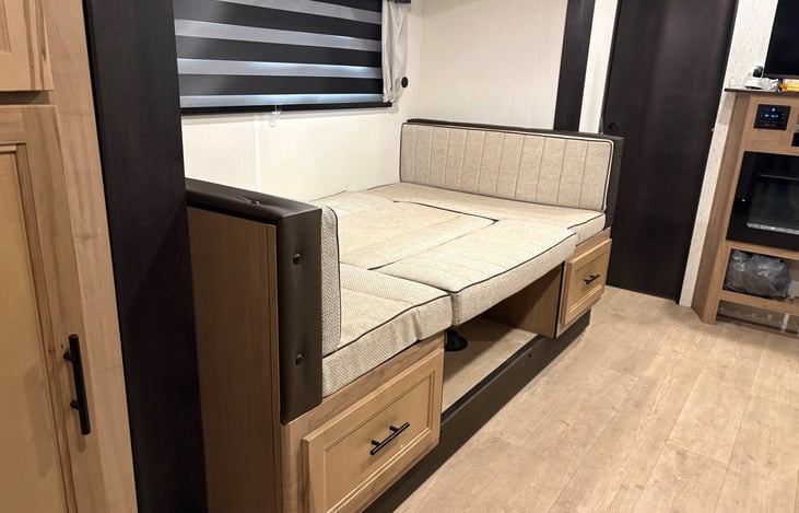 U-Shaped Dinette that folds to a full size bed for extra sleeping room. Storage to the left and underneath dinette.