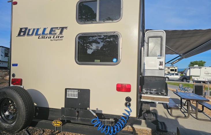 Rear of the camper, showing the outside water hose helpful when cooking.