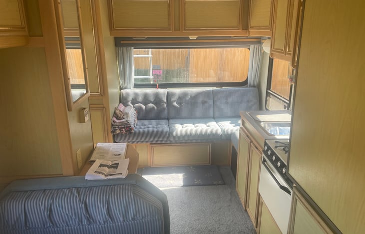 A rear couch can be collapsed into a queen bed. There is also a second removable table and storage under the bed, with access from the inside and outside through a locking cargo door.