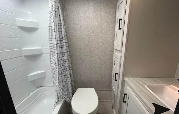 Rear Bathroom has lots of storage cupboard space and 6' stand up space in shower. I added towel racks after this picture.