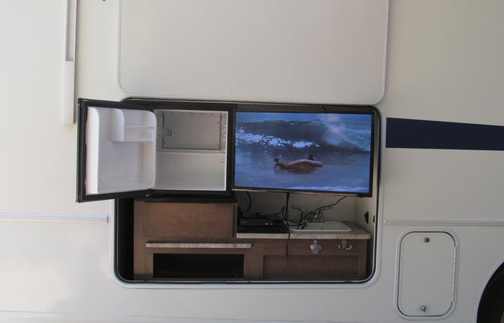 Outdoor entertainment area.  TV with DVD player, mini-fridge and sink.