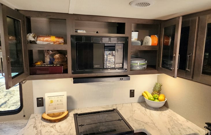 Plates and more storage around the microwave.