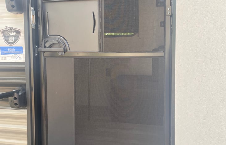 Storm door with screen and safety latch