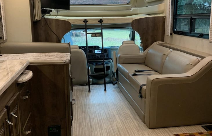 View from back to front. Leather couch also folds into another sleeping area. Plus top bunk sleeps two comfortable.