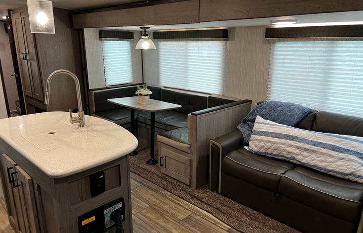 Living area including pull out couch (queen) and dining area that sleeps two